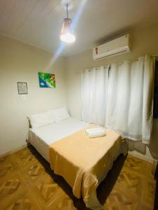 um pequeno quarto com 2 camas e uma janela em Caraiva Hostel em Caraíva