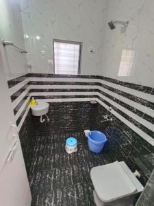 a bathroom with a toilet and a sink at KIYAN VILLA in Daman