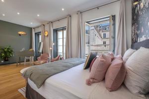 a bedroom with a large bed with pink pillows at Escale Rochelaise, chambre privé avec acces toute l'année au SPA chauffée et sauna in La Rochelle