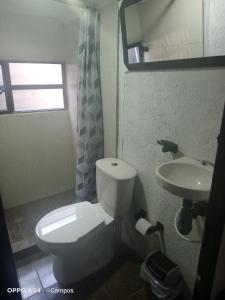 a bathroom with a white toilet and a sink at CASA BAHAREQUE HOSPEDAJE in Monguí