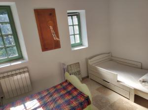 a bedroom with a bed and a dresser and windows at Les Deux Voutes - Gite en Cévennes in Saint-André-de-Majencoules