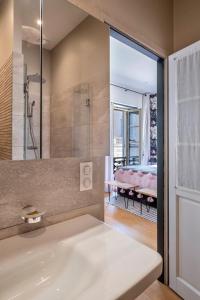 拉羅歇爾的住宿－Escale Rochelaise, chambre privé avec acces toute l'année au SPA chauffée et sauna，带淋浴和盥洗盆的浴室以及一间客房。