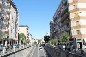 a city street with cars driving down the street at Arcobaleno in Stazione in Saronno
