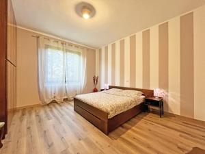 1 dormitorio con cama y pared a rayas en B Home Tresoldi en Cassano dʼAdda