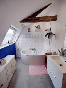 La grande salle de bains est pourvue d'une baignoire et d'un lavabo. dans l'établissement Grande maison familiale avec jardin proximité Lille, à Wattignies