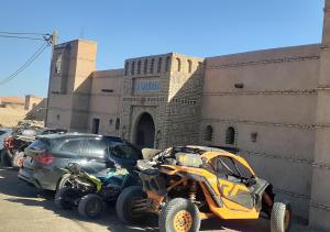 due quad e un'auto parcheggiata di fronte a un edificio di Casa laman a Merzouga