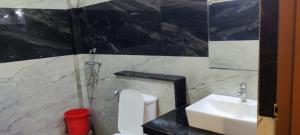 Moms Hostel في آغْرا: حمام به مرحاض أبيض ومغسلة