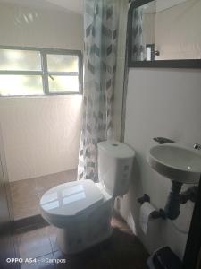 a bathroom with a toilet and a sink at CASA BAHAREQUE HOSPEDAJE in Monguí