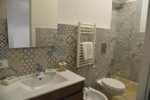 a bathroom with a sink and a toilet at Altemura Suites in Bari