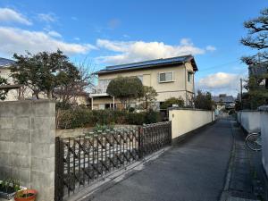 a house with a fence in front of a street at Sakura house in Kyoto