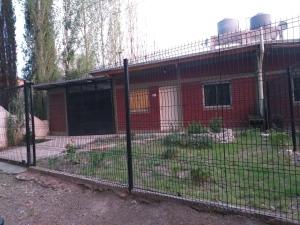 a fence in front of a red brick building at Casa con pileta Pedriel I in Ciudad Lujan de Cuyo