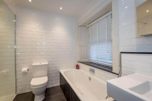 uma casa de banho com um WC, uma banheira e um lavatório. em Luxury St Andrews Apartment - 5 mins to Old Course em St. Andrews