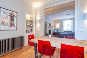 uma sala de jantar com uma mesa e cadeiras vermelhas em Luxury St Andrews Apartment - 5 mins to Old Course em St. Andrews
