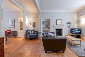 a living room with a couch and a fireplace at Lockhart House in St. Andrews