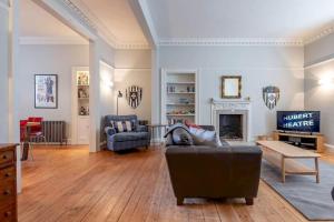 a living room with a couch and a fireplace at Luxury St Andrews Apartment - 5 mins to Old Course in St. Andrews