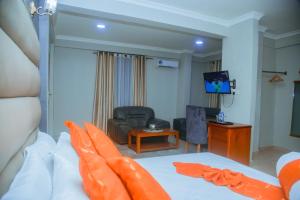 Camera con letto, divano e TV. di LE GRAND MARIE HOTEL a Dar es Salaam