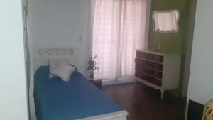 um quarto com uma cama azul e uma janela em Casa de Playa en Chapadmalal em Chapadmalal
