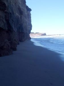 uma praia com um grande penhasco junto ao oceano em Casa de Playa en Chapadmalal em Chapadmalal