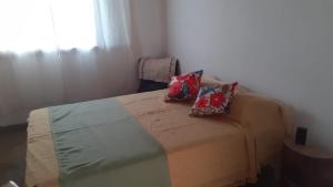 um quarto com uma cama com duas almofadas em Casa de Playa en Chapadmalal em Chapadmalal