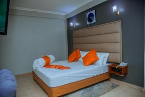 a bedroom with a bed with orange pillows at LE GRAND MARIE HOTEL in Dar es Salaam