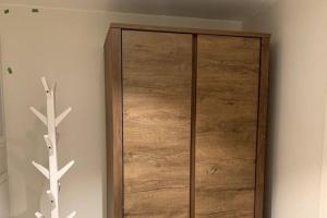 a wooden cabinet in the corner of a room at Hotell-leilighet i sentrum in Bodø