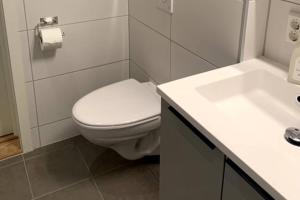 uma casa de banho com um WC branco e um lavatório. em Hotell-leilighet i sentrum em Bodø