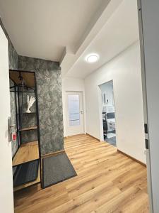 ein leeres Wohnzimmer mit Holzboden und Spiegel in der Unterkunft Apartment Lori in Mönchengladbach