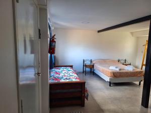 Un dormitorio con 2 camas y un banco. en BO Alquileres Temporarios en Ushuaia