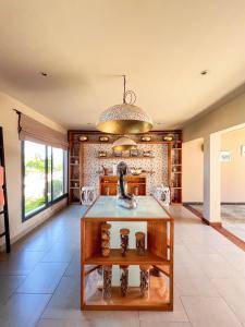 ein großes Wohnzimmer mit einem Tisch in der Mitte in der Unterkunft Palm Beach Resort & Spa in Ambondrona