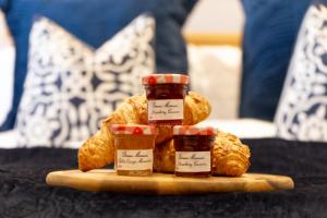 a plate with two jars of jam on a table at 4-Bed Apartment With Cosy Pub in Pontypool