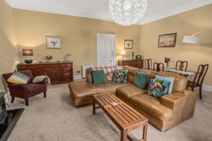 a living room with a couch and a table at Panoramic Sea Views - Stunning 3BD Apt & Balcony in Oban