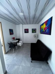 a living room with a table and a painting on the wall at Apartamento moderno con balcón - Pitalito Huila in Pitalito +7 photos