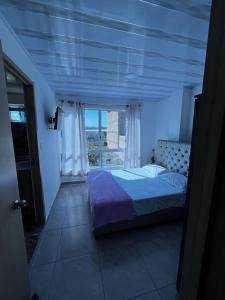 ein Schlafzimmer mit einem Bett und einem großen Fenster in der Unterkunft Apto Escalini Mansión Pitalito in Pitalito