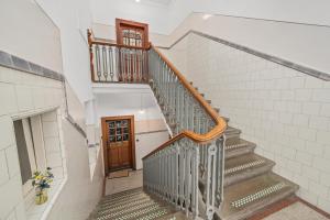 a staircase in a house with a wooden door at Panoramic Sea Views - Stunning 3BD Apt & Balcony in Oban