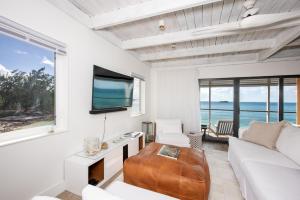 sala de estar con sofá blanco y TV en Touch of Class Cottage home, en Savannah Sound