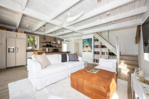 sala de estar con sofá blanco y techo de madera en Touch of Class Cottage home, en Savannah Sound
