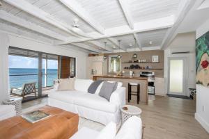 a living room with a white couch and a kitchen at Touch of Class Cottage home in Savannah Sound