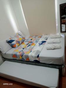 un letto con piumone e cuscini sopra di Dreamy 2BR condo, with a golf course view a Cebu City