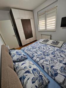 een slaapkamer met 2 bedden met blauwe en witte lakens bij Apartman Vukota Pirot in Pirot