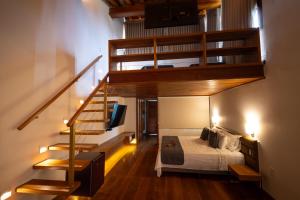 ein Schlafzimmer mit einem Bett und einer Wendeltreppe in der Unterkunft Tiradentes Boutique Hotel in Tiradentes