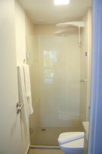 a bathroom with a toilet and a glass shower at APTO 107-Pé na Areia Praia do Maceio - 2 suites, 2 banheiros+SPA Jacuzzi+Roupas de cama in São Miguel do Gostoso +24 photos