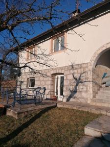 a building with a table and benches in the yard at Studio u selu Mačkat in Mačkat +4 photos