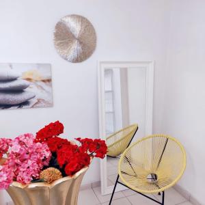 a room with a vase of red flowers and a chair at ALBACHIARA INN Residence Apartments in Ameglia