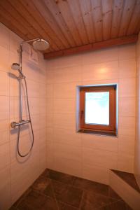 La salle de bains est pourvue d'une douche et d'une fenêtre. dans l'établissement Alpengasthof Gutenbrunn, à Mallnitz