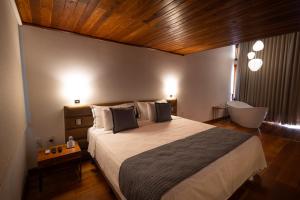 - une chambre avec un grand lit et un plafond en bois dans l'établissement Tiradentes Boutique Hotel, à Tiradentes