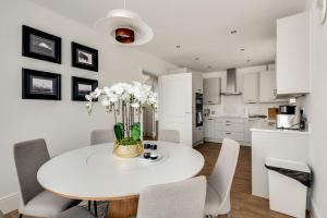 eine Küche und ein Esszimmer mit einem weißen Tisch und Stühlen in der Unterkunft Tranquil 4-Bed Oasis Modern Chic House in Oxford