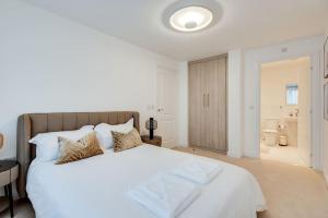 1 Schlafzimmer mit einem großen weißen Bett und einem Badezimmer in der Unterkunft Tranquil 4-Bed Oasis Modern Chic House in Oxford