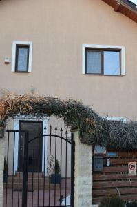 a building with a gate with a ivy covered fence at Cozy apartment 2 rooms Prelungirea Ghencea in Bragadiru