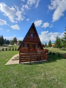 eine Hütte mit einem Strohdach auf einem Grasfeld in der Unterkunft Mountain House Tadić 1 in Bajina Bašta