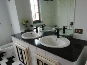 Su domus de Corinne في Tratalias: حمام مع مغسلتين ومرحاض
